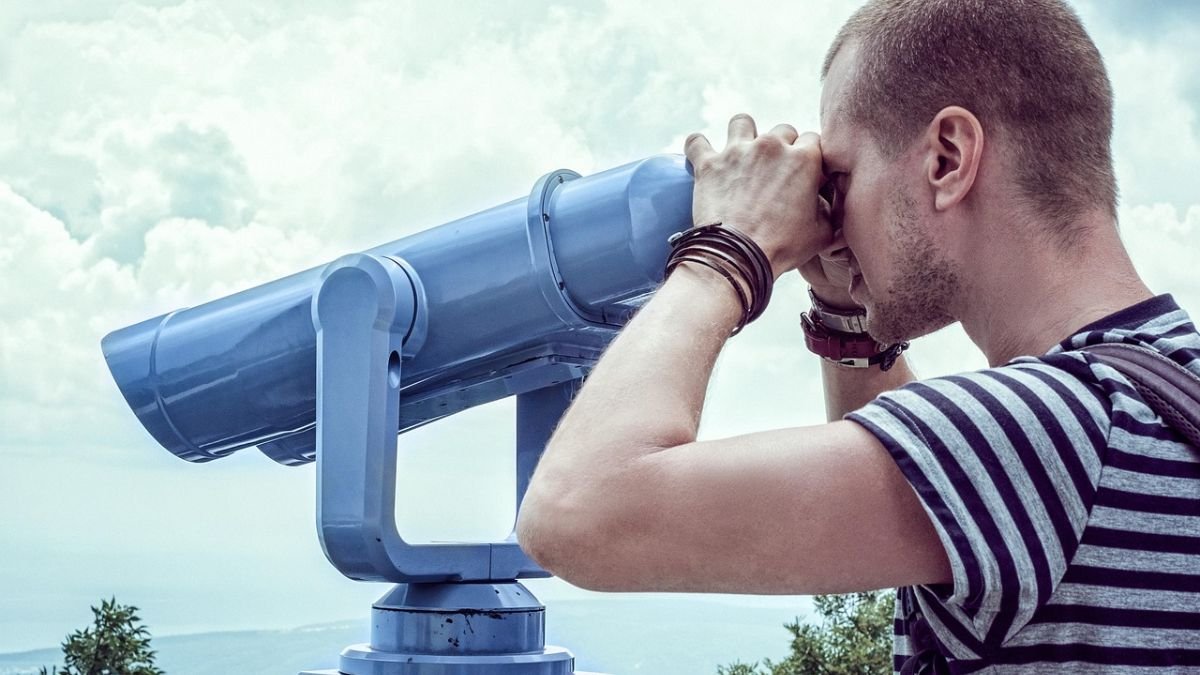 homem olhando binoculos