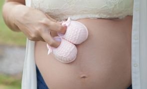 mulher gravida com sapatinhos na barriga