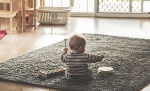 bebe sentado no chao brincando